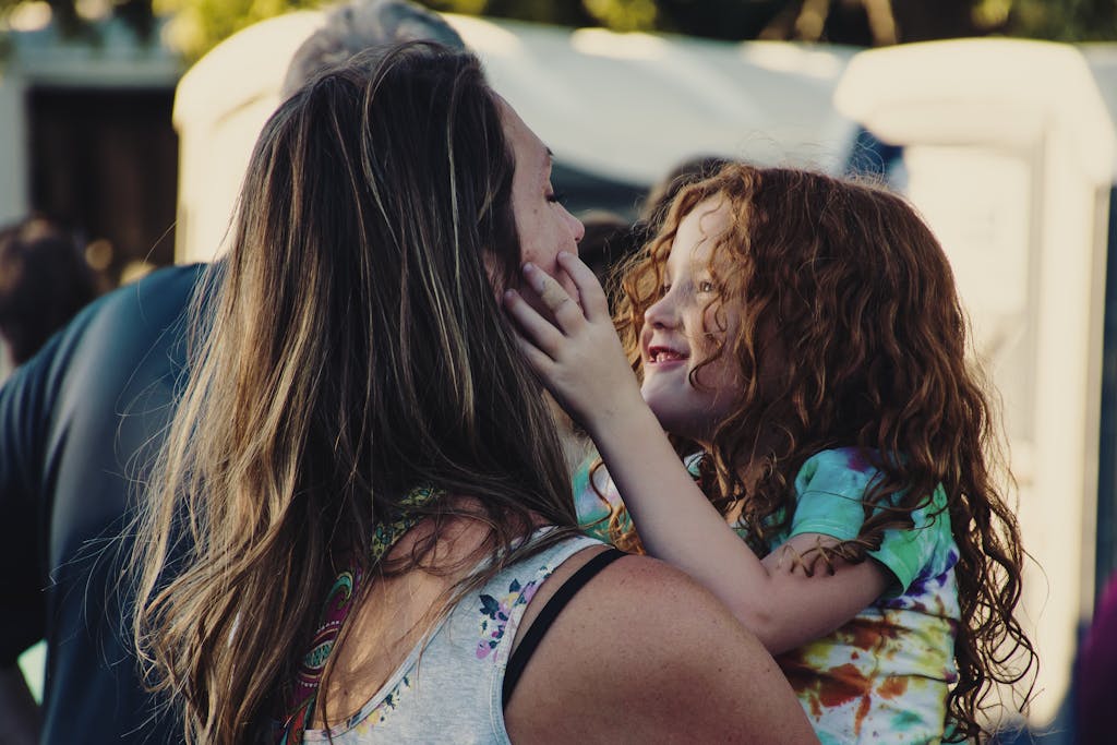 A heartwarming scene of mother and daughter embracing in a sunlit outdoor setting, symbolizing love and happiness.